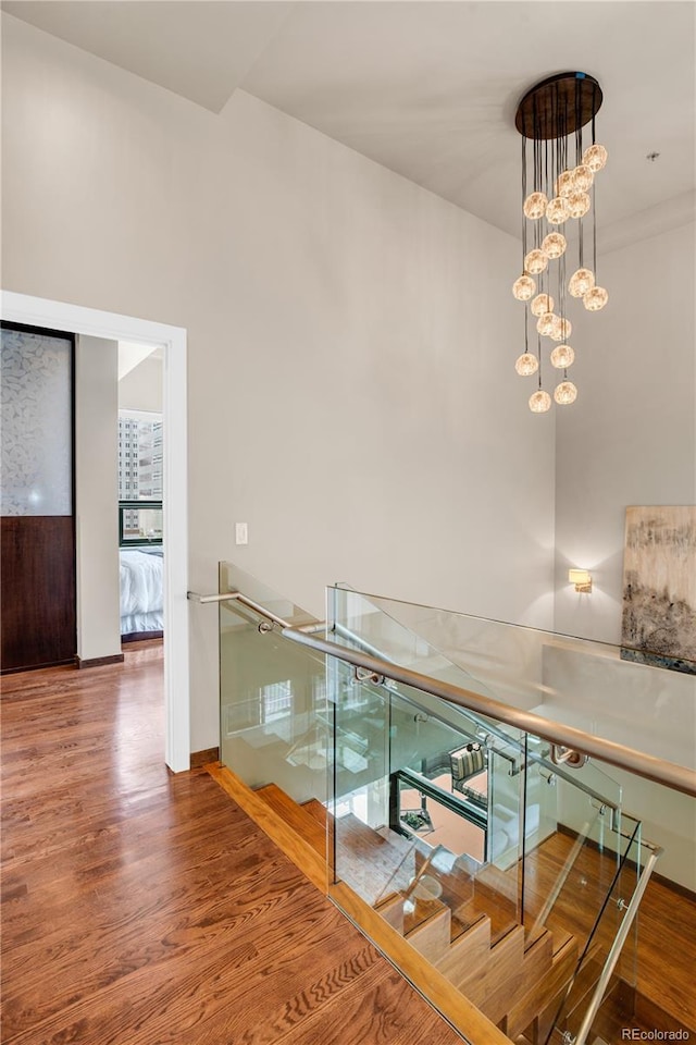 stairway featuring hardwood / wood-style flooring and a chandelier