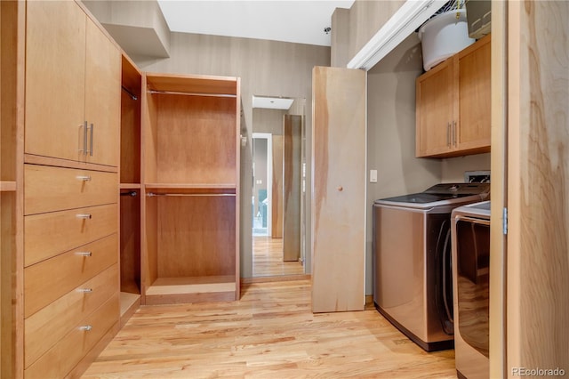 washroom with cabinets, washer and clothes dryer, and light hardwood / wood-style floors