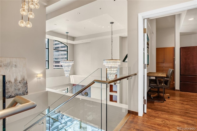 stairway featuring an inviting chandelier and hardwood / wood-style floors