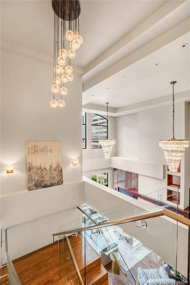 staircase featuring wood-type flooring and a notable chandelier