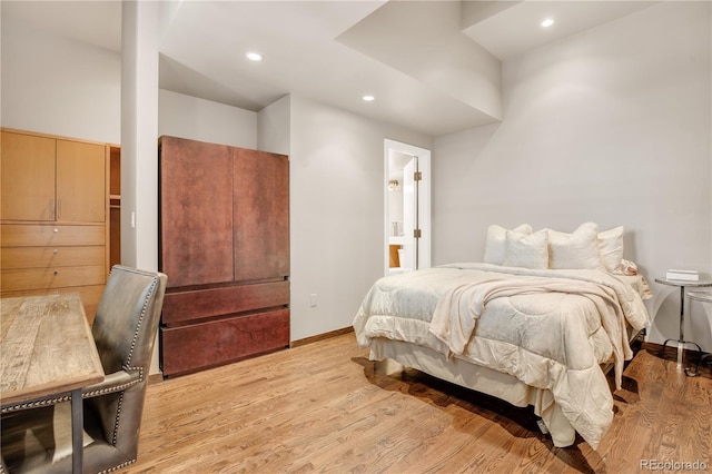 bedroom with light hardwood / wood-style floors and ensuite bathroom