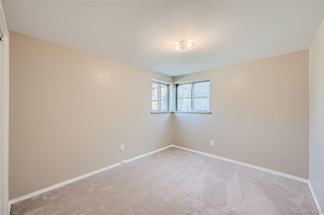 carpeted empty room with a textured ceiling