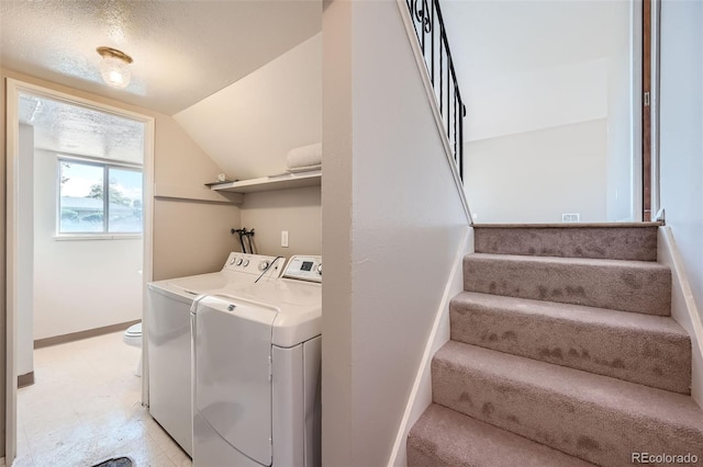 washroom with a textured ceiling and washing machine and clothes dryer