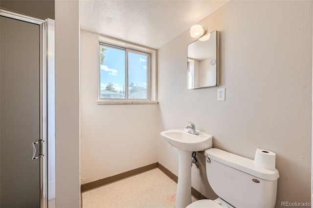 bathroom featuring toilet, a textured ceiling, and an enclosed shower