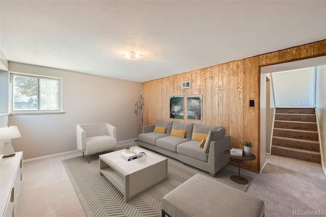 living room featuring light carpet and wood walls