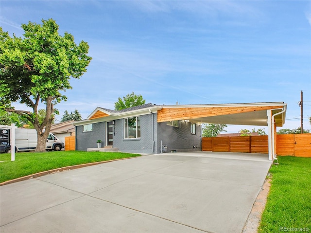 7126 Joan St, Denver, CO 80221 - view of front of home featuring driveway, an attached carport, and brick siding