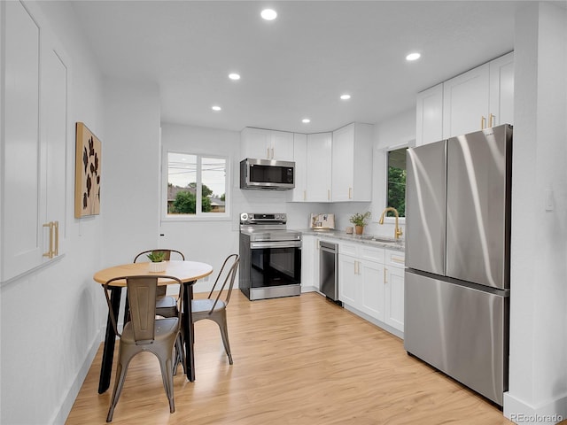 7126 Joan St, Denver, CO 80221 - kitchen with stainless steel appliances, a sink, plenty of natural light, white cabinets, and recessed lighting