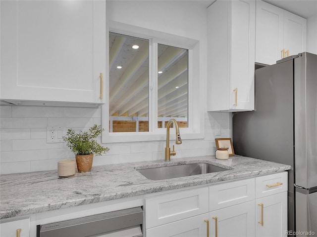 7126 Joan St, Denver, CO 80221 - kitchen featuring freestanding refrigerator, a sink, white cabinetry, backsplash, and recessed lighting