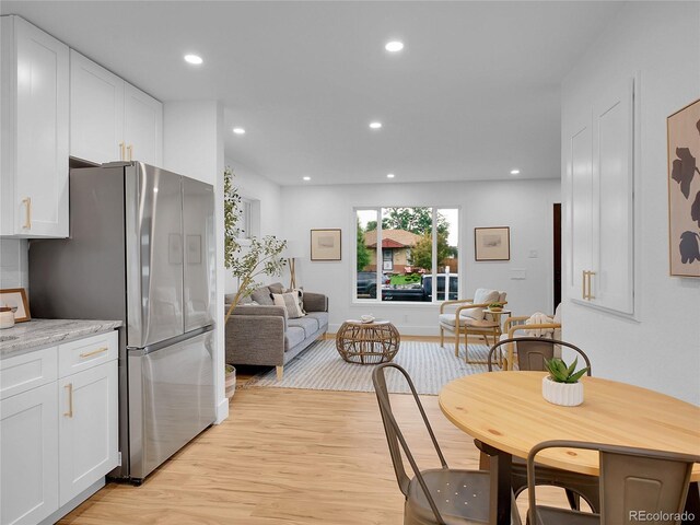 7126 Joan St, Denver, CO 80221 - kitchen with freestanding refrigerator, light wood-style flooring, white cabinets, recessed lighting, and open floor plan