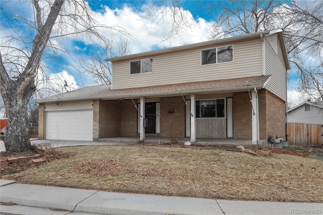 traditional home with brick siding, fence, a porch, concrete driveway, and a garage