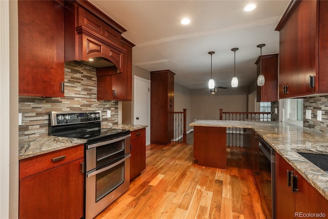 kitchen featuring backsplash, light stone countertops, pendant lighting, light wood-style flooring, and appliances with stainless steel finishes