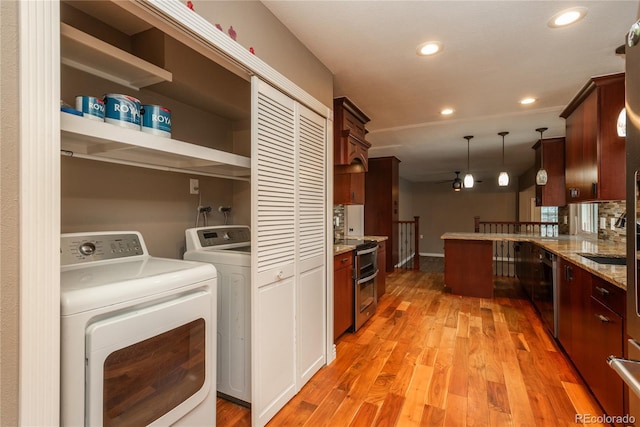 kitchen featuring light wood finished floors, washing machine and clothes dryer, recessed lighting, appliances with stainless steel finishes, and pendant lighting