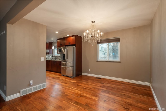 kitchen featuring wood-type flooring, visible vents, appliances with stainless steel finishes, and a sink