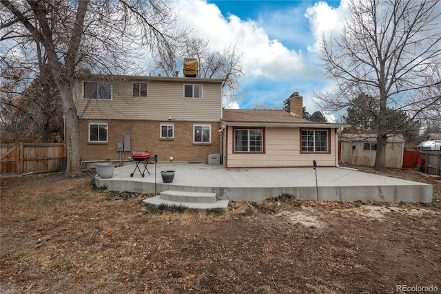 back of property featuring a patio, a fenced backyard, and brick siding