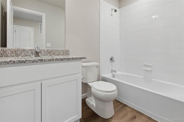 full bath with toilet, bathtub / shower combination, wood finished floors, and vanity