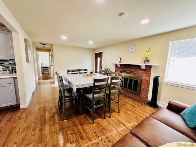 dining space featuring a fireplace and light hardwood / wood-style floors