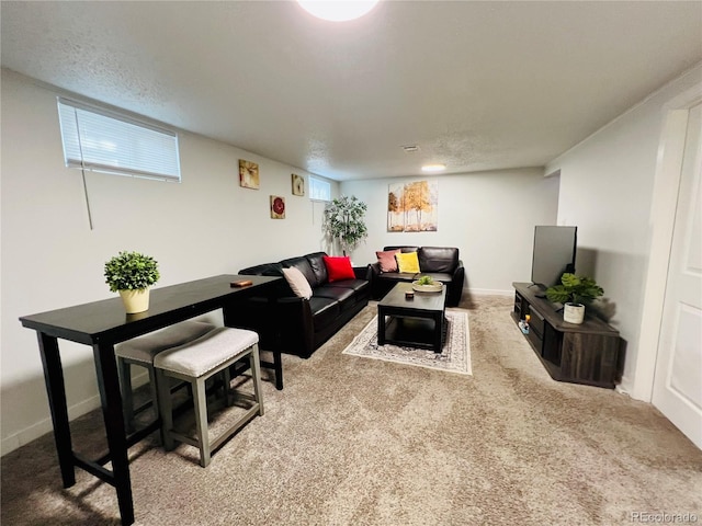 living room featuring light colored carpet, a textured ceiling, and baseboards