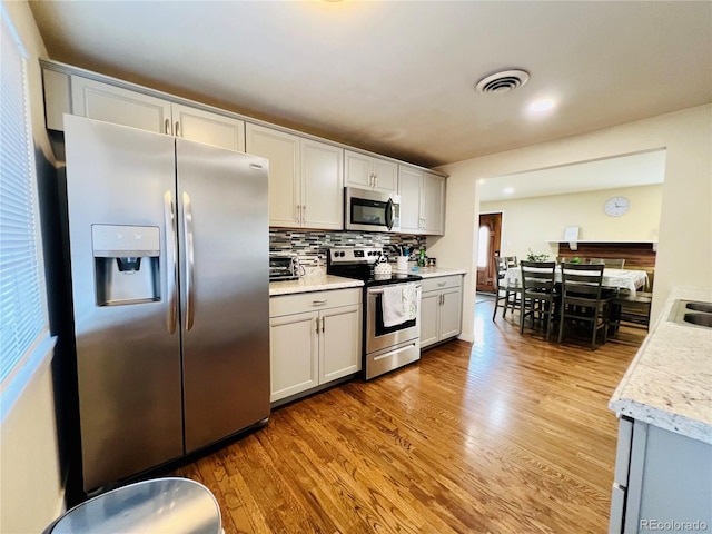 kitchen featuring appliances with stainless steel finishes, light countertops, visible vents, and light wood finished floors