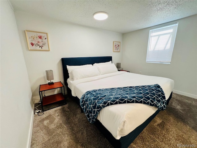 carpeted bedroom featuring baseboards and a textured ceiling