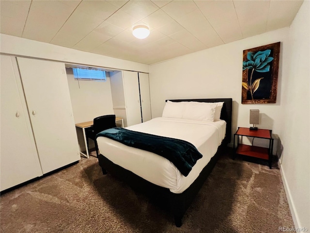 bedroom with baseboards, dark carpet, and a closet