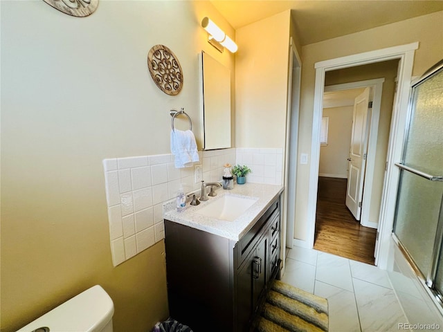 bathroom featuring toilet, backsplash, and vanity