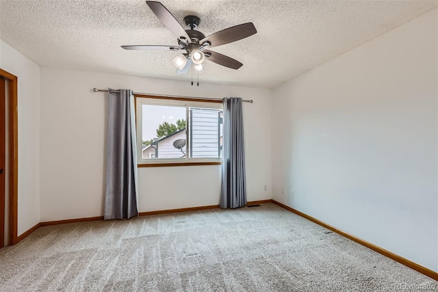 carpeted spare room featuring ceiling fan, a textured ceiling, and baseboards