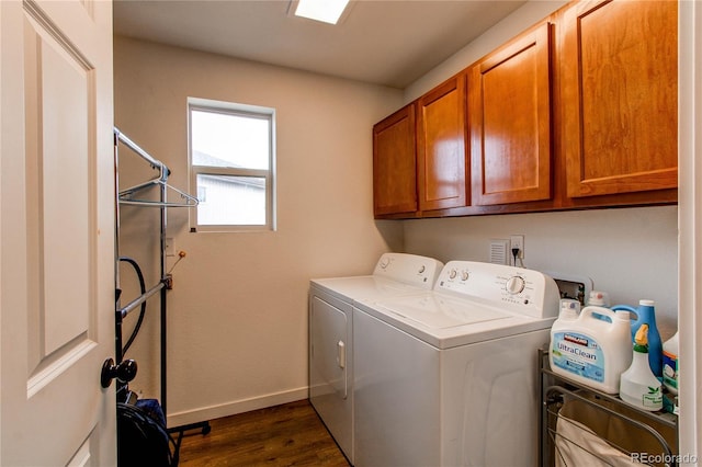 clothes washing area featuring dark hardwood / wood-style flooring, cabinets, and washing machine and clothes dryer