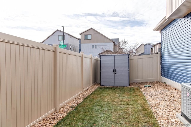 view of yard featuring a shed and central AC unit