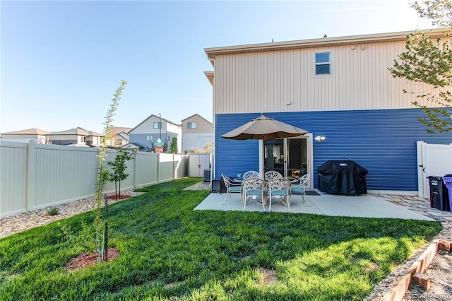 rear view of house with a fenced backyard, a patio, and a yard