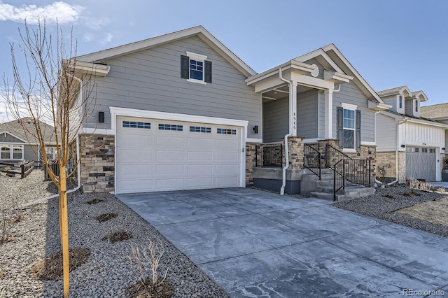 view of front of house with stone siding, driveway, and a garage