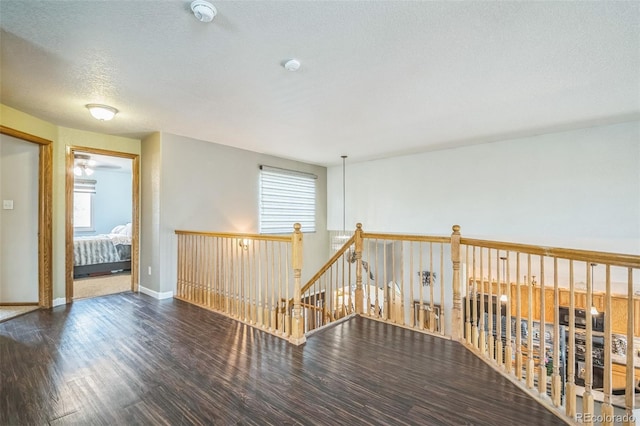 unfurnished room with wood finished floors, baseboards, a smoke detector, and a textured ceiling