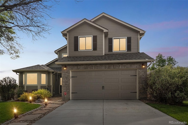 traditional-style house featuring driveway, an attached garage, and roof with shingles