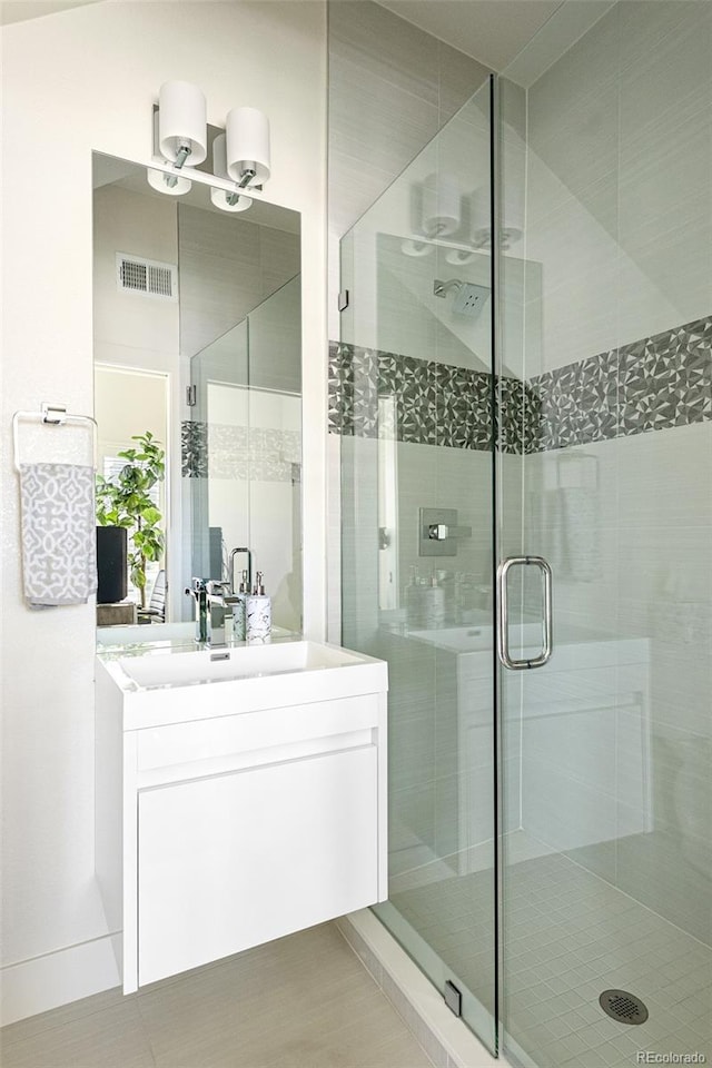 bathroom with vanity, visible vents, and a stall shower