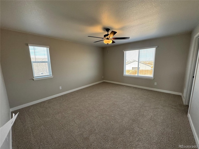 carpeted empty room featuring baseboards, plenty of natural light, a textured ceiling, and ceiling fan