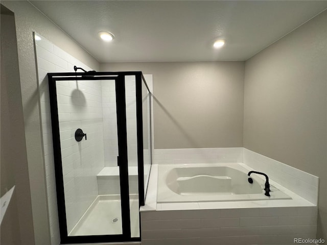 full bathroom featuring a shower stall and a garden tub