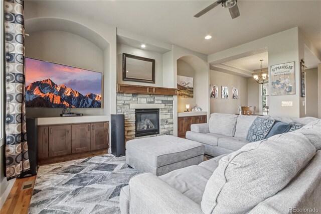7258 Spanish Bay Dr, Windsor, CO 80550 - living area with wood finished floors, ceiling fan, a stone fireplace, a chandelier, and recessed lighting