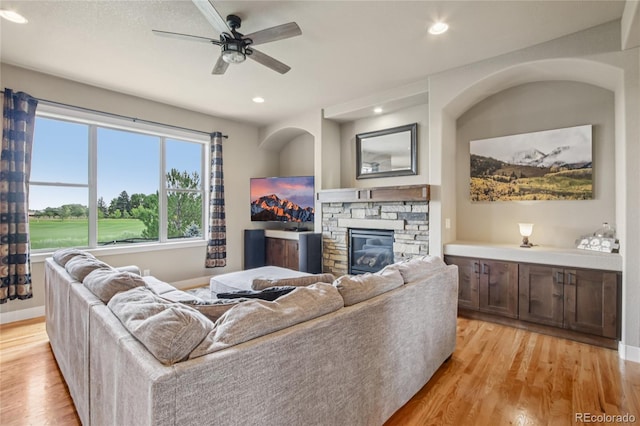 7258 Spanish Bay Dr, Windsor, CO 80550 - living room featuring light wood-type flooring, a fireplace, ceiling fan, and recessed lighting