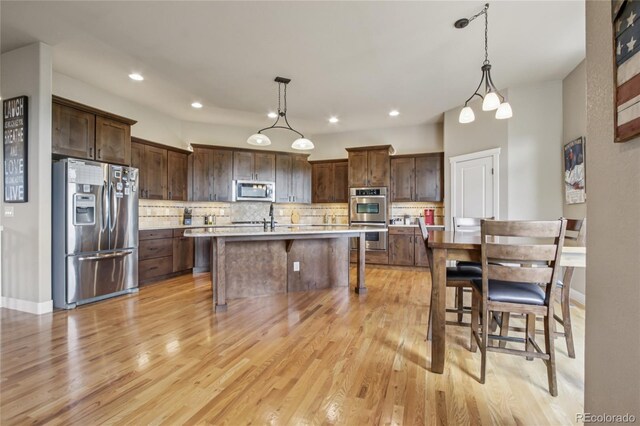 7258 Spanish Bay Dr, Windsor, CO 80550 - kitchen with stainless steel appliances, light countertops, tasteful backsplash, light wood-type flooring, and recessed lighting