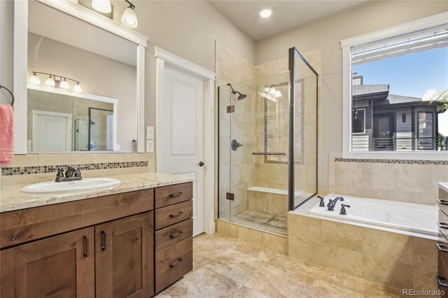 7258 Spanish Bay Dr, Windsor, CO 80550 - full bathroom featuring vanity, a stall shower, a bath, and backsplash