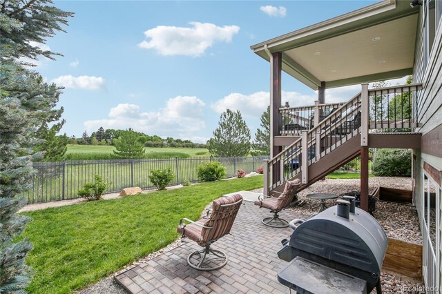 7258 Spanish Bay Dr, Windsor, CO 80550 - fenced backyard featuring a patio area, area for grilling, and stairway