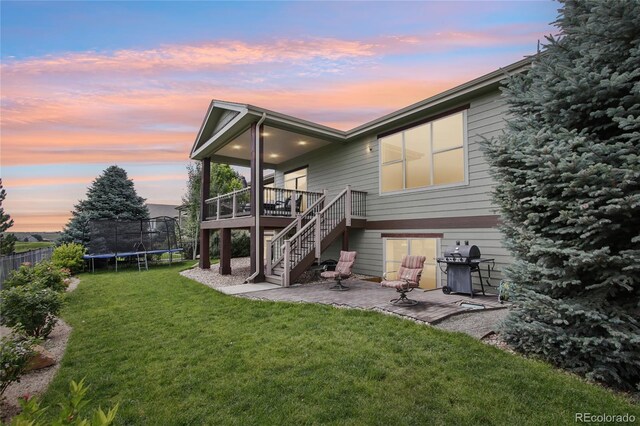 7258 Spanish Bay Dr, Windsor, CO 80550 - back of house featuring a patio area, a trampoline, stairway, and a wooden deck