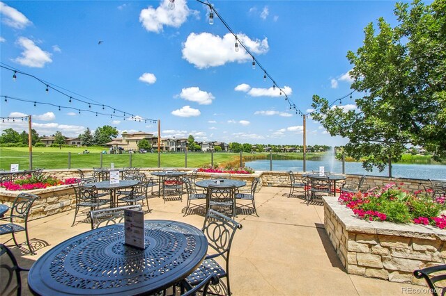 7258 Spanish Bay Dr, Windsor, CO 80550 - view of patio featuring outdoor dining space and a water view