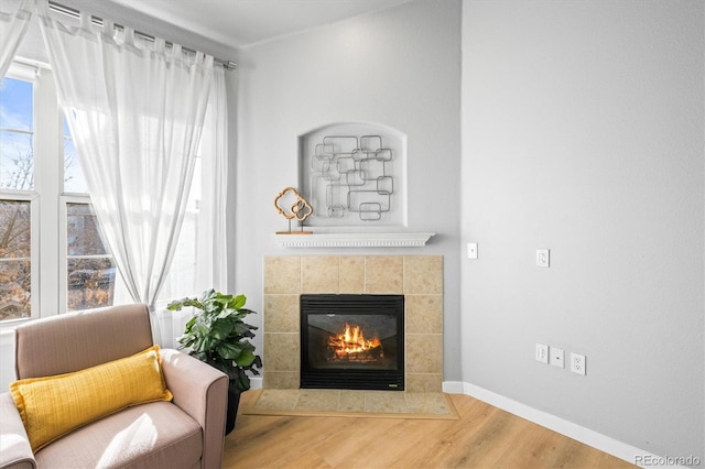 living area featuring a tile fireplace and hardwood / wood-style floors