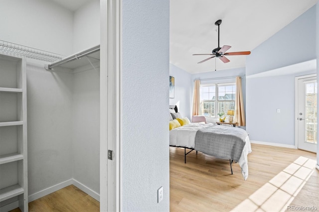 bedroom with multiple windows, ceiling fan, lofted ceiling, and hardwood / wood-style flooring