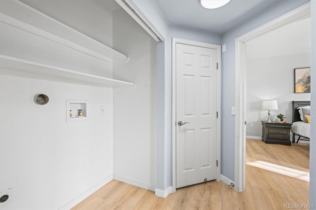 clothes washing area featuring hardwood / wood-style flooring and hookup for a washing machine