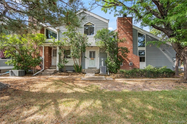 view of front of property with cooling unit and a front yard