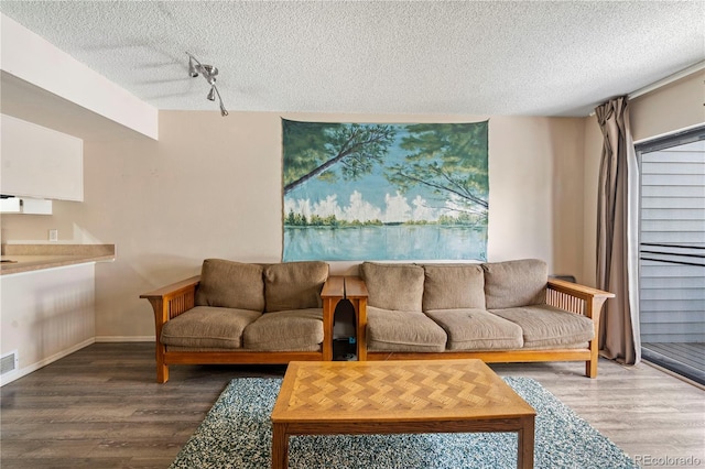 living room featuring hardwood / wood-style floors, a textured ceiling, and track lighting