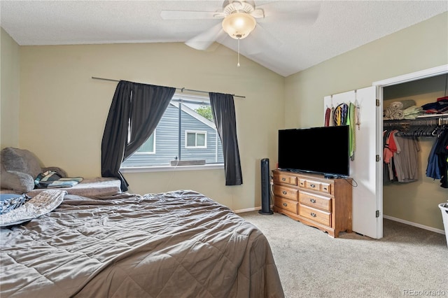 carpeted bedroom with a textured ceiling, a closet, vaulted ceiling, and ceiling fan