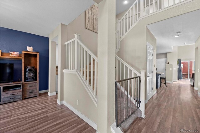 stairway featuring wood finished floors and baseboards