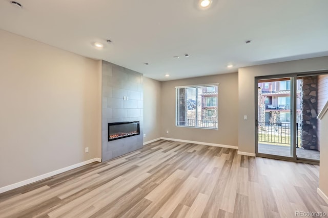 unfurnished living room featuring a fireplace and light hardwood / wood-style flooring